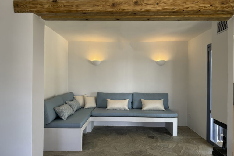 Ανακαίνιση παραδοσιακού σπιτιού στην Τήνο – Εσωτερικός χώρος με χτιστό καναπέ και φυσικά υλικά από το αρχιτεκτονικό γραφείο Scale Design Studio.